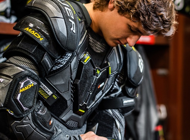 player putting on hockey shoulder pads