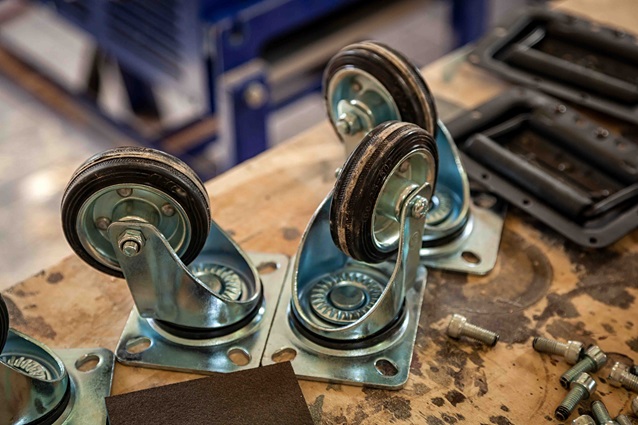 Furniture caster wheel made from metal and plastic on wooden table, Industrial spinning wheel.