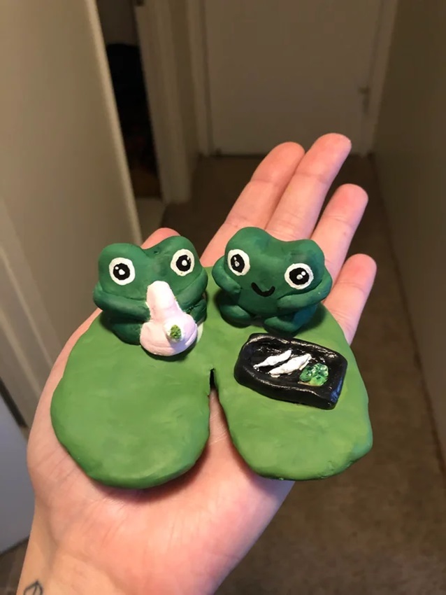 person holding frogs made out from polymer clay