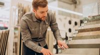 man choosing ceramic tiles from store